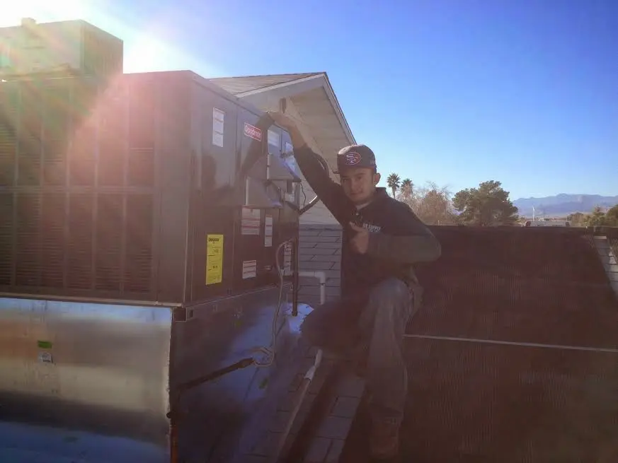 HVAC technician performing HVAC Inspection on a rooftop unit in Micco
